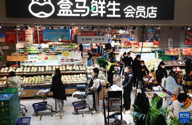 1月15日，西安市曲江新区的居民在一家大型超市排队选购商品。