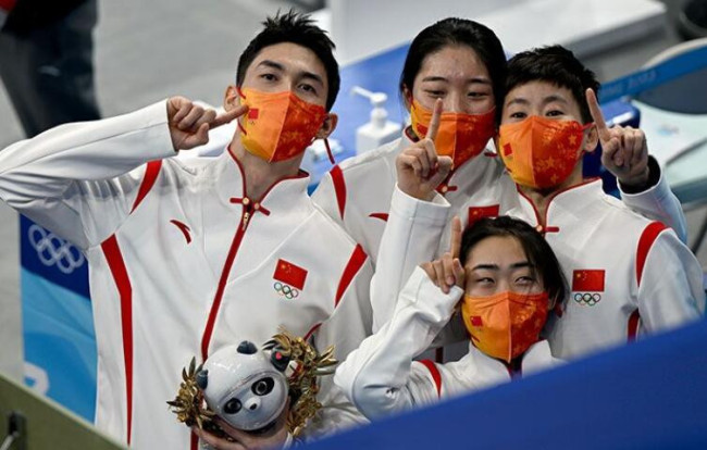 颁奖仪式后，中国短道速滑队四名队员向着镜头庆祝胜利。