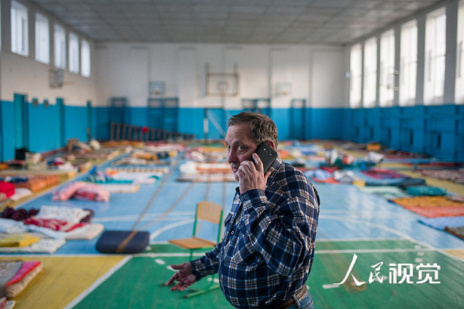 当地时间2022年3月4日，乌克兰利沃夫地区的一个小镇，一名学校校长和学生缝制军用伪装网。 