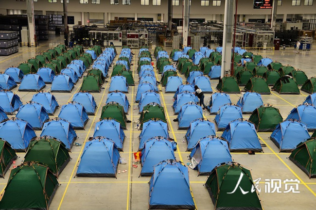 2022年5月2日晚，江苏省太仓高新区一家汽车零部件制造企业生产车间内，实行闭环管理的车间员工、管理人员准备进入帐篷小家休息。