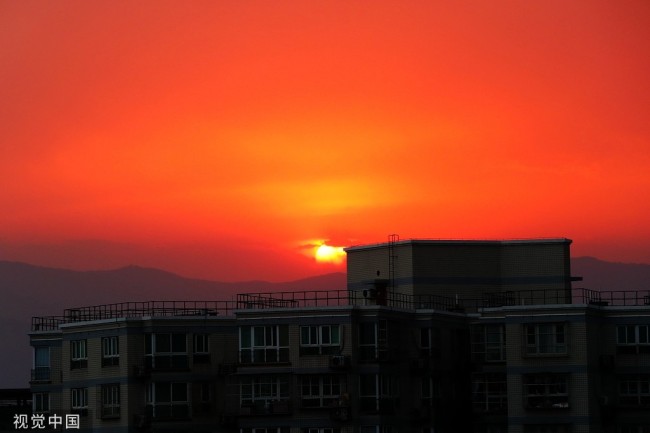 2022年5月19日，北京海淀区世纪城远望西山落日余晖红似火。