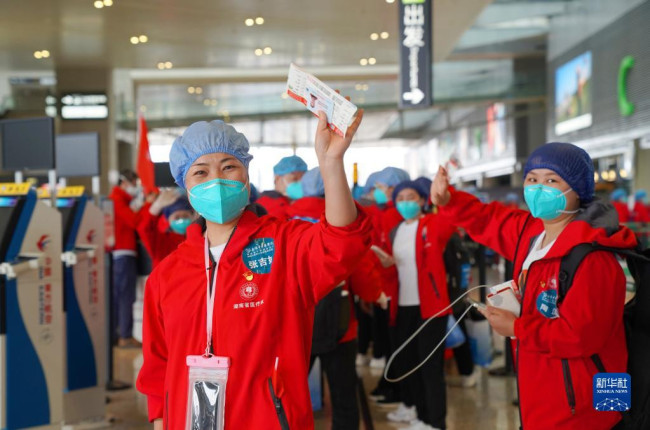 5月23日，在上海虹桥国际机场，一名拿到登机牌的医疗队队员准备登机安检。