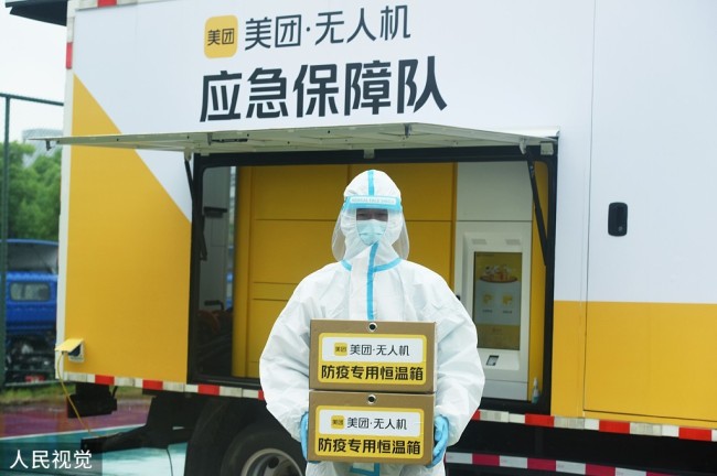 2022年5月24日，一名核酸检测人员在杭州市余杭区华正科技园内将美团无人机刚空运来的核酸样本送往检测实验室。