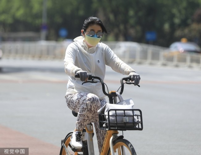 2022年5月28日，北京，市民穿戴严实骑行在路上。