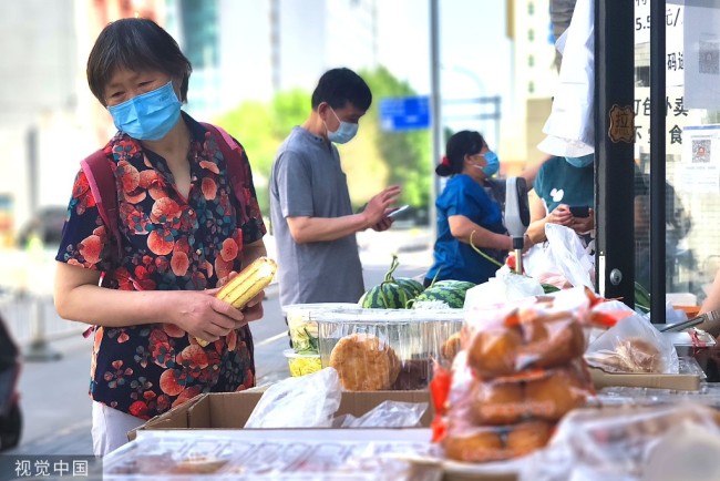 2022年5月28日，市民在北京市海淀区知春路一家饭店前选购新鲜蔬菜等生活物资。