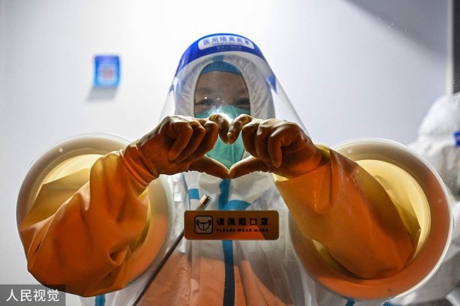 2022年5月31日,上海静安区,核酸医护人员在镜头前"比心".