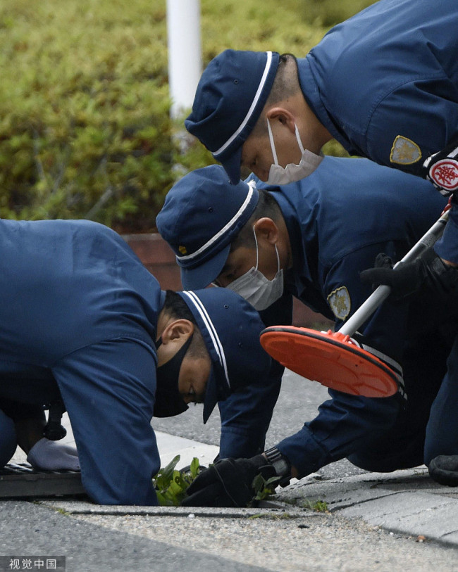 当地时间2022年7月14日，日本奈良，调查人员在前首相安倍晋三遇刺现场附近工作。