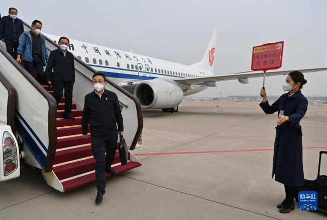 10月13日，来自宁夏回族自治区的党的二十大代表乘飞机抵达北京首都国际机场。新华社记者 陈益宸 摄