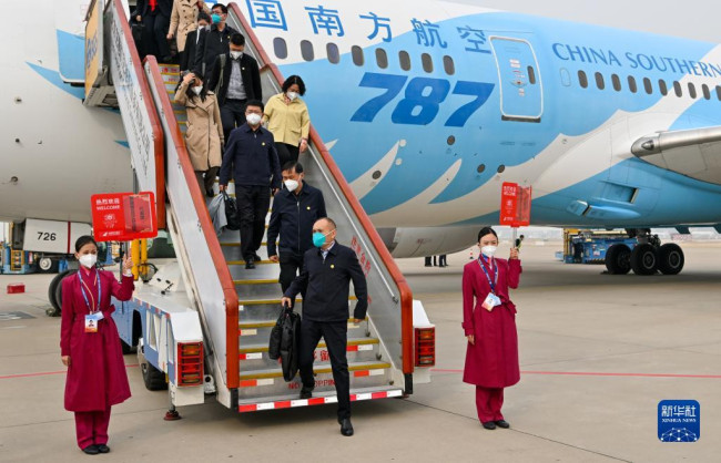 10月13日，来自新疆维吾尔自治区的党的二十大代表乘飞机抵达北京首都国际机场。新华社记者 陈益宸 摄