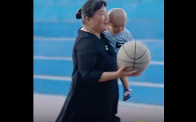 农村阿姨给孩子换完尿布接着打篮球