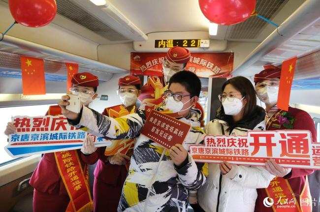 12月30日，首趟京滨高铁D6601次列车上旅客与乘务员合影留念。