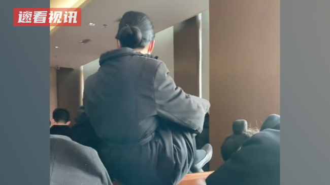 女生为不打扰同学休息坐桌上抱腿跨过，还摆了一个得意姿势