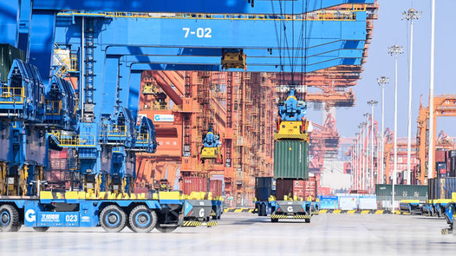 在广西钦州港自动化集装箱码头，无人驾驶车辆在转运集装箱（2023年2月25日摄）。新华社记者张爱林摄