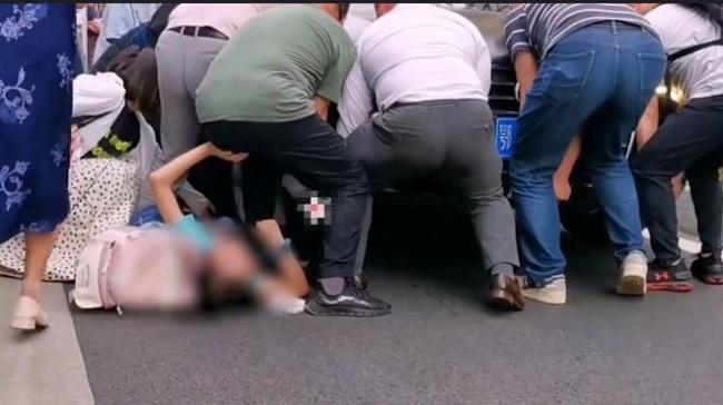女孩不慎被车压路人相救 并将女孩抱到路边等待救护车的到来