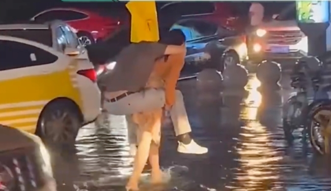 女子暴雨天背男友过马路：还穿着高跟鞋！