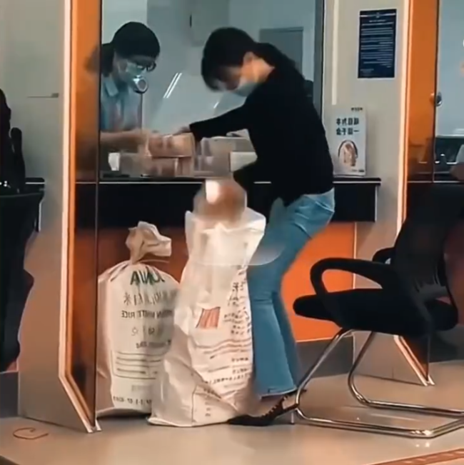 女子拿麻袋装钱吓懵众人