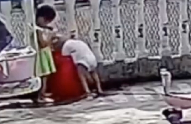 小孩玩水不慎栽进水桶