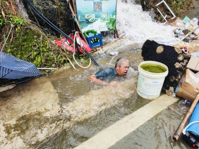 58岁村干部潜入1米5深的排水渠徒手清淤  