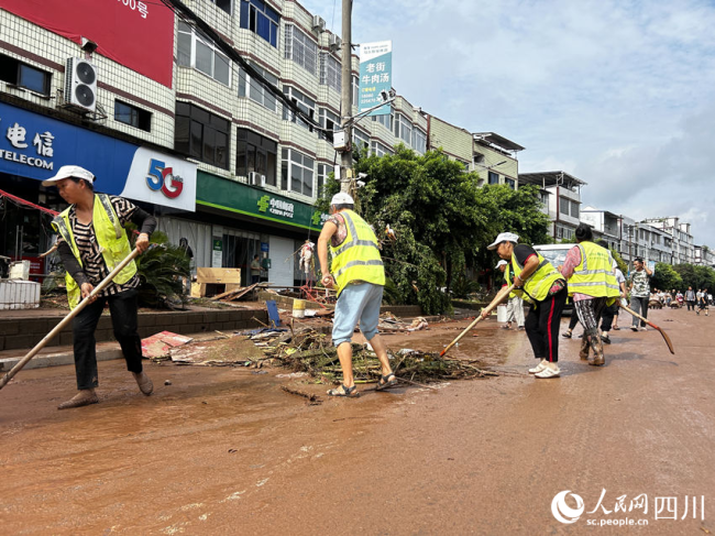 场镇内涝消退 党员志愿者协助清淤 全力恢复群众生活秩序