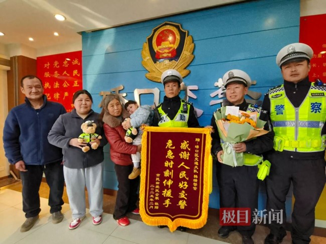 女子帶孩子向輔警韓靖送錦旗