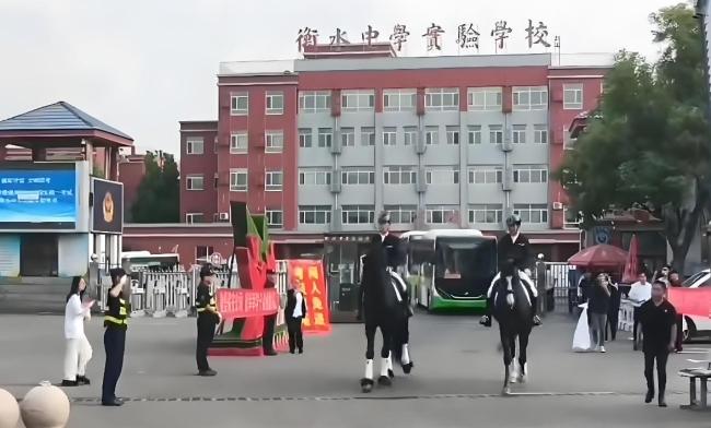 家长身着旗袍手拿向日葵等候 为考生加油打气