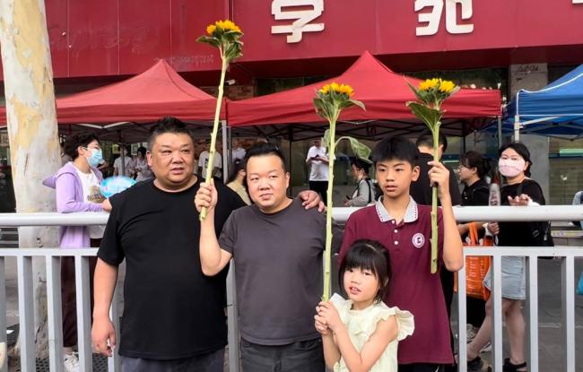 家长身旗袍拿向日葵等候考生 期盼一举夺“葵”