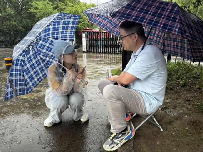 高考首日降雨 有人追梦也有人守护 雨中温情护考路
