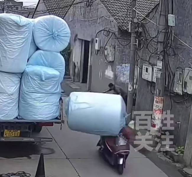 监控：2人骑电动车经过被掉落货物砸倒