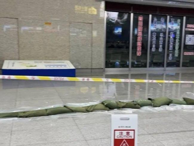 成都东站旅客踩沙包出站 强降雨致积水严重