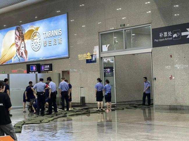 成都东站旅客踩沙包出站 强降雨致积水严重