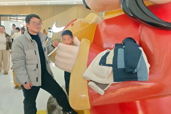 小孩哥卡在财神爷“掌心”出不来 好奇心引发的“尴尬”