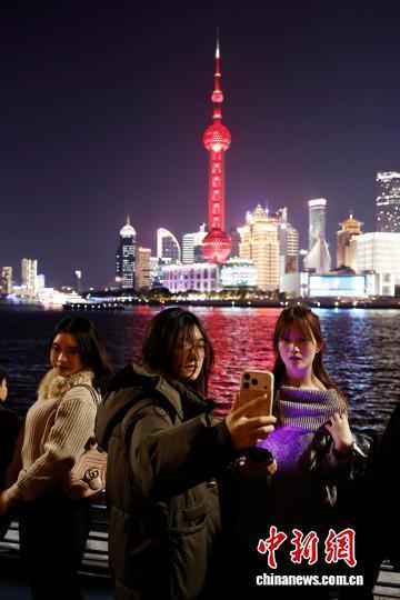 游客欣赏上海黄浦江两岸夜景 流光溢彩映外滩