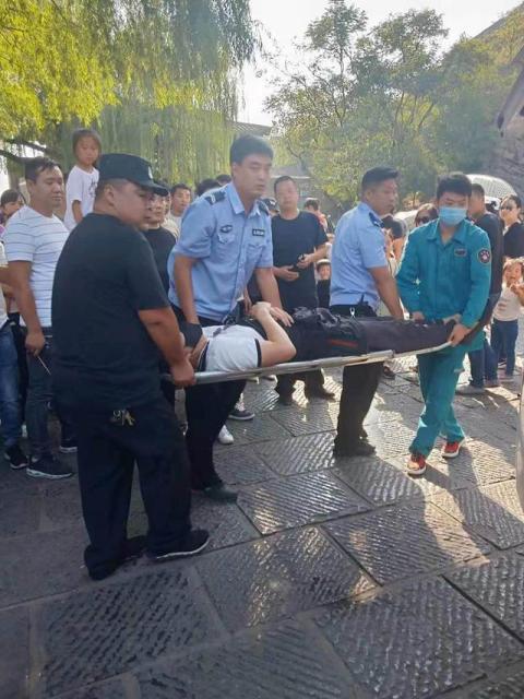 龙门石窟一游客突发疾病被抬上救护车 多方协助紧急送医