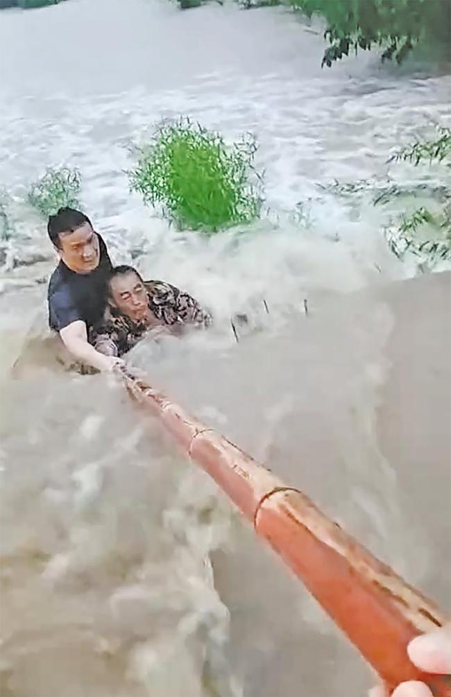 男子被洪水冲倒村支书跳水救人