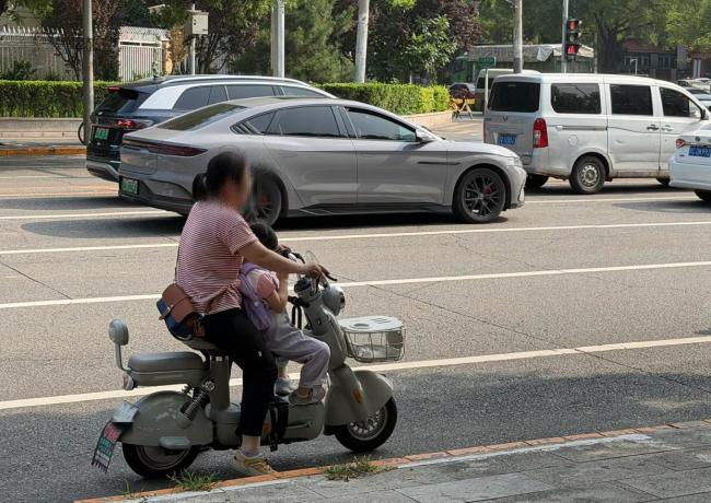 骑电动车带娃到底应该坐前面还是后面