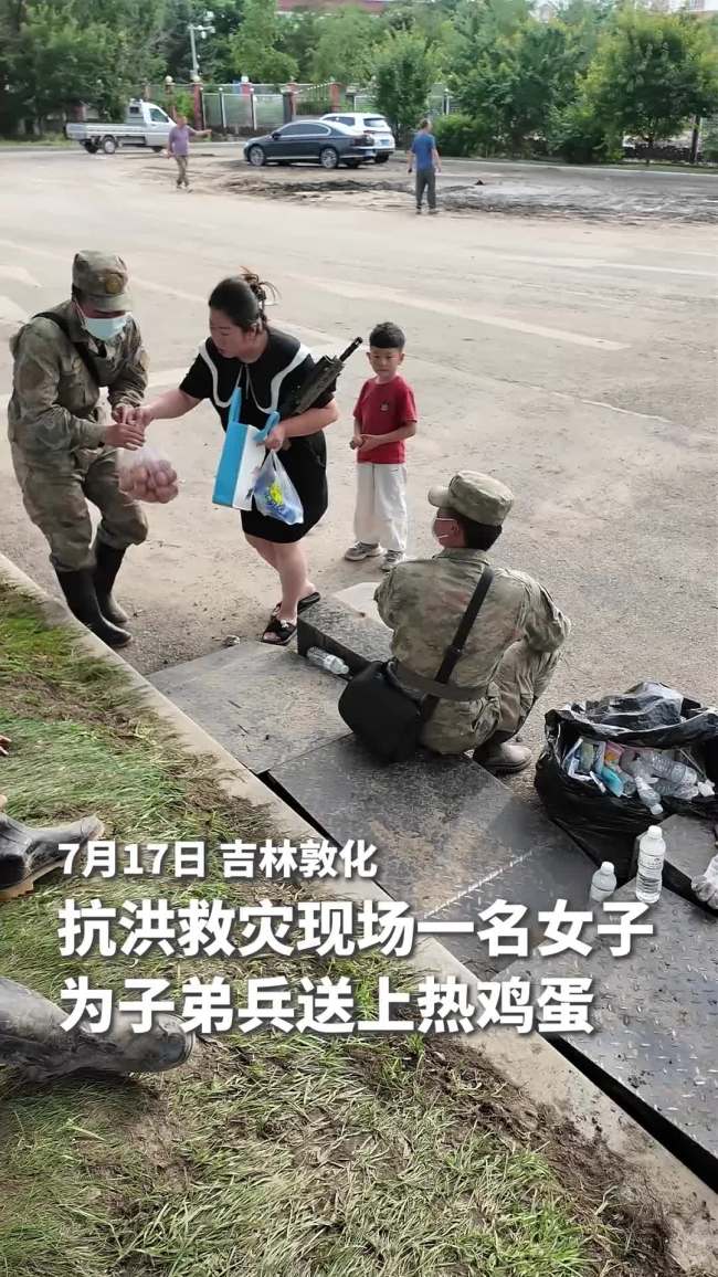 女子牵着孩子为子弟兵送上热鸡蛋