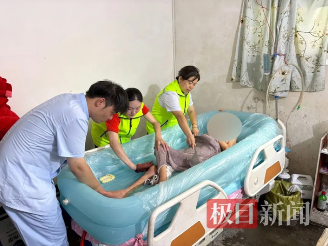 蔡苗苗、暴福清和刘海驰正进行助浴服务