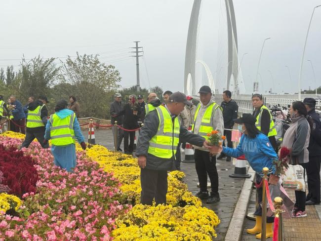 北京上百位市民雨中排队 接国庆鲜 花香传递节日温情