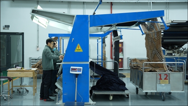 陕西驼城绒业科技有限公司车间,工人正在有条不紊整理面料