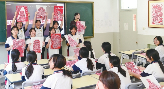 临汾市文化艺术学校学生展示自己制作的山西古建刻纸作品