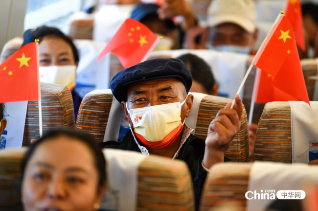 西藏基层干部赴京参观学习班第二期学员在列车内挥舞国旗