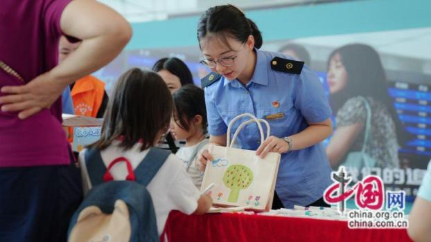 成都東站工作人員提醒乘客不要打傘 文明暑運活動啟動